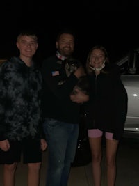 a group of people standing in front of a truck at night