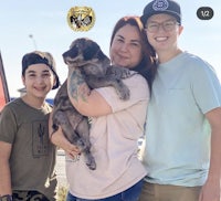 a family holding a puppy in front of a truck