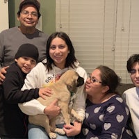 a family is posing for a picture with a puppy