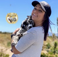 a woman in a hat holding a puppy